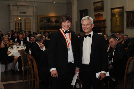 Rory Burns (left), winner of  the 2010 Walter Lawrence Trophy award for the highest scoring MCC Universities batsman, receives the special silver medallion and a cheque for £1,000 from Mike Griffith, MCC Chairman of Cricket